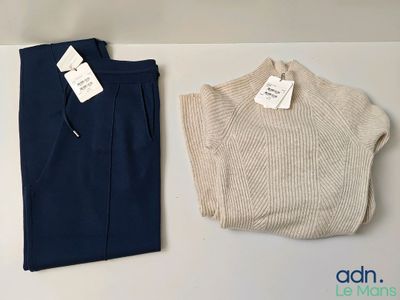 deux pantalons et un pull posés sur une table