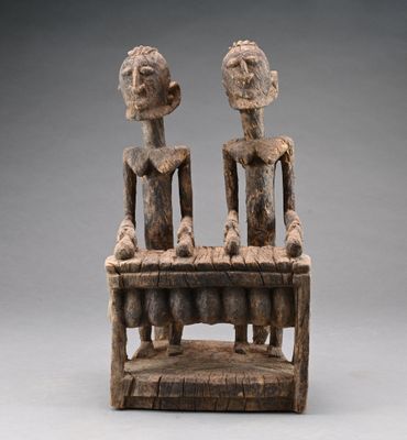 une sculpture en bois représentant deux personnes assises sur un banc