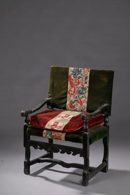 une vieille chaise sur laquelle est posé un coussin rouge et vert