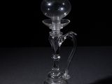 a clear glass candle holder on a black table