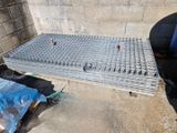 un homme qui se tient à côté d'une grille métallique