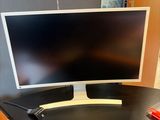 a computer monitor sitting on a desk with a keyboard and mouse