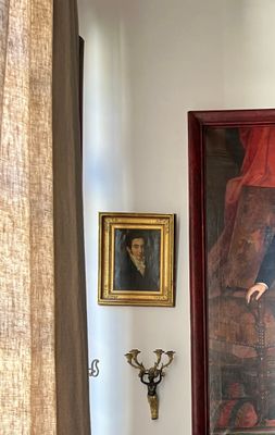 a picture of a man standing in a room with a painting on the wall