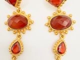 a pair of gold and garnet stone earrings
