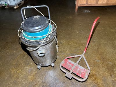 a bucket and a broom on the floor in a garage