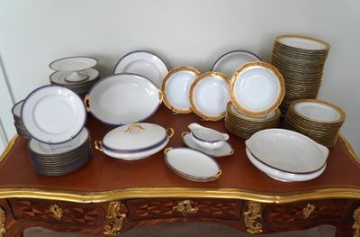une table sur laquelle se trouvent beaucoup d'assiettes et de bols