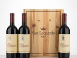 three bottles of red wine in front of a wooden box