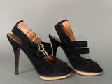 a pair of black sued high heel shoes with a gold buckle