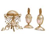 three pieces of gold and mother of pearl jewelry on a white background