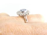 a woman ' s hand holding a ring with a blue stone on it