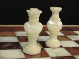 two white vases sitting on a chess board