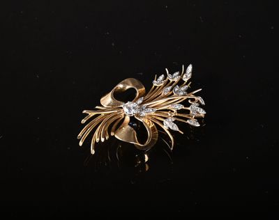 un gros plan d'une broche en or sertie de diamants sur un fond noir
