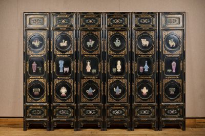 un paravent sur lequel sont disposés plusieurs vases