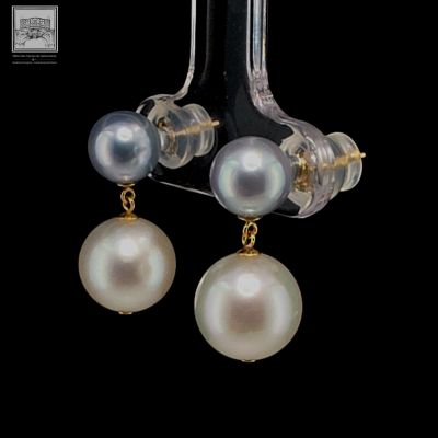 pair of pearl and gold earrings on a black background