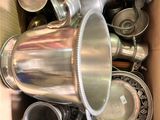une boîte remplie de plats et de tasses en argent