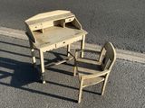 a small desk and chair sitting on the side of the road