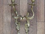two candles that are on the wall on the wooden floor