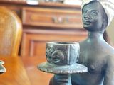 a statue of a woman holding a cup and saucer