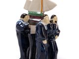 three figurines of people standing next to each other