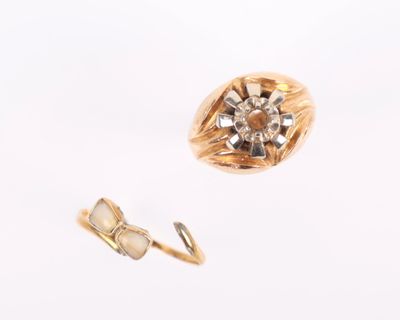 une bague en or ornée d'une fleur, à côté d'une paire de boucles d'oreilles