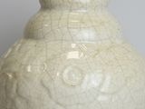a white vase that has a cracky surface on it