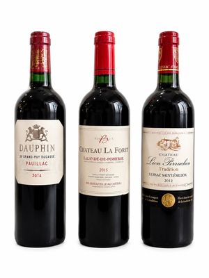 trois bouteilles de vin rouge sont alignées sur une surface blanche