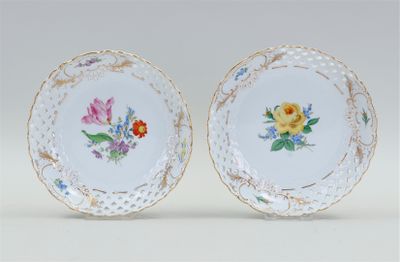 pair of porcelain plates with floral designs on them on a white surface