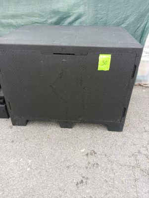 une enceinte noire sur laquelle est collé un autocollant jaune