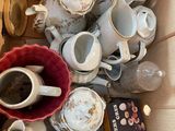 une boîte en carton remplie de tasses à café et de soucoupes