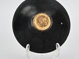 a black plate with a gold medallion on it