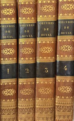 several books are lined up in a row on a shelf