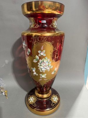 un vase rouge et doré posé sur une table