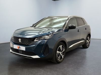 Une voiture bleue est garée dans une pièce au sol noir.