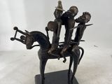 figurine en bronze représentant un homme à cheval, avec trois autres hommes à son dos