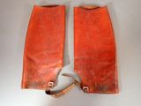pair of red leather boots with metal buckles on a white surface