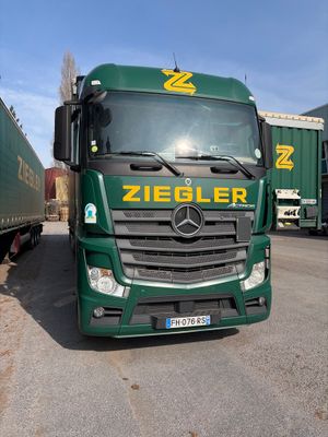 un camion vert garé sur un parking