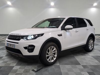 La Land Rover blanche est garée sur un sol carrelé à damier.