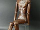 statue d'une femme assise sur une chaise, sur fond noir