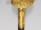 a gold and black sword with a bird on top of it