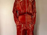 une veste et un pantalon en cuir rouge posés sur un mannequin dans une pièce