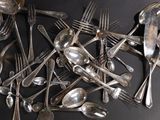 a lot of silver spoons and forks on the table