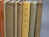 several books are lined up in a row on a gray surface