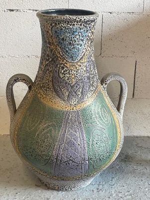 a vase that is sitting on a table next to a brick wall