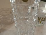 un vase en verre transparent posé sur une table à côté de tasses