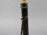 a close up of a black and gold samurai sword on a wooden stand
