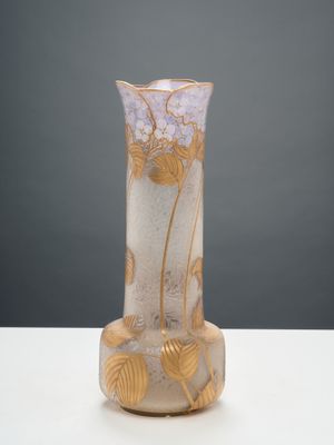 un vase en verre posé sur une table, sur fond gris