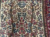 an antique persian rug with a floral design on a white ground