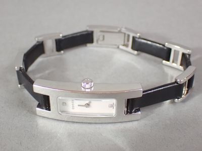 a black and silver bracelet with a white dial