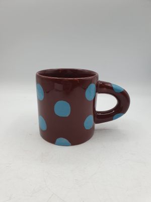 tasse à café à pois marron et bleus sur un fond blanc