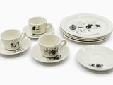 quatre tasses, deux soucoupes et une assiette sur la table